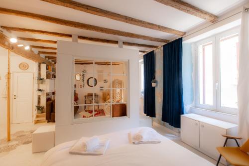 a white bedroom with a bed and a window at Rosalia Apartment in Koper