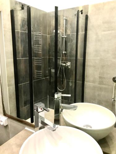 La salle de bains est pourvue d'une douche et d'un lavabo blanc. dans l'établissement Le portalet centre historique, à Hyères