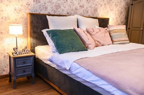 een bed met kussens en een lamp op een tafel bij Apartament de poveste pe plajă în Resort de Lux in Năvodari