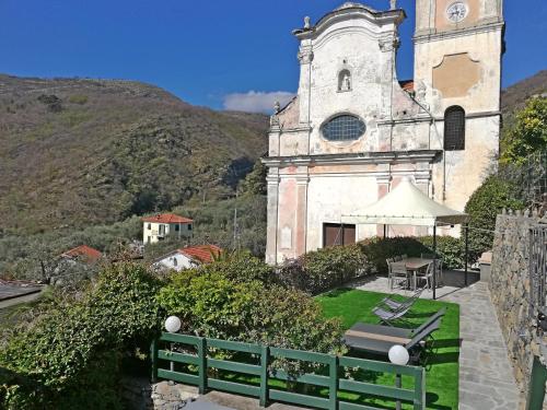 an old building with a clock tower in front of it at Case Vacanze Borgo Faraldi in Villa Faraldi