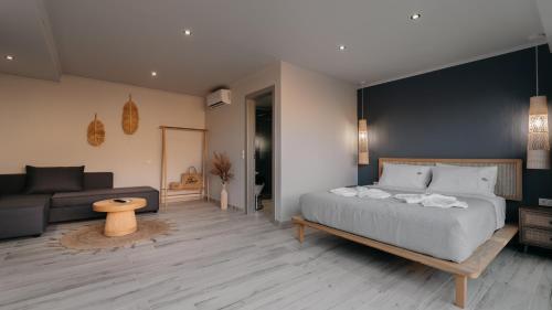 a bedroom with a large bed and a couch at Zante Calinica Hotel in Tsilivi