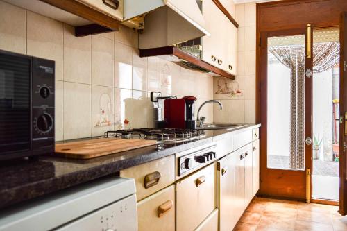 a kitchen with a sink and a stove top oven at Ca La Valls - Casa céntrica ideal para familias in Tortellá