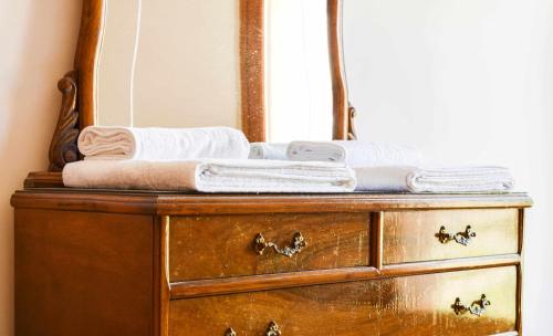 a wooden dresser with a mirror and towels on it at Ca La Valls - Casa céntrica ideal para familias in Tortellá