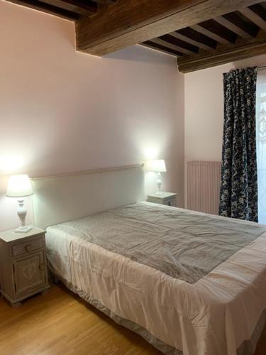 a bedroom with a bed and two lamps on tables at La tour de Jade in Avallon