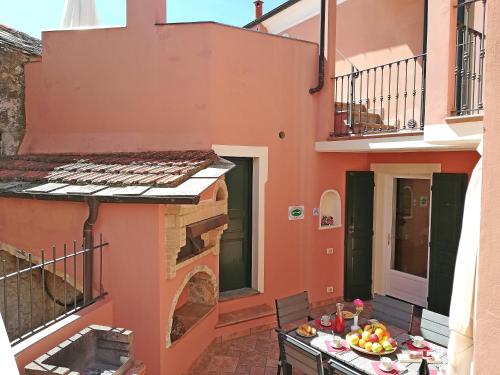 a balcony of a house with a table with fruit on it at Case Vacanze Borgo Faraldi in Villa Faraldi