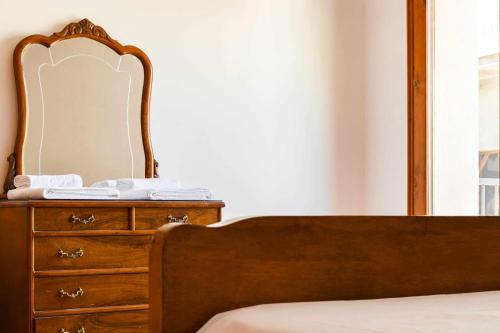 a bedroom with a bed and a dresser with a mirror at Ca La Valls - Casa céntrica ideal para familias in Tortellá