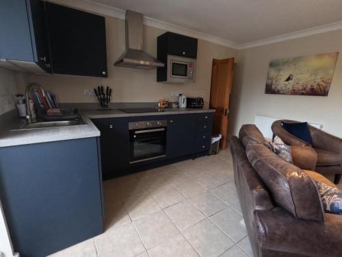 a kitchen with a sink and a couch in a room at The Grove Falmouth in Falmouth