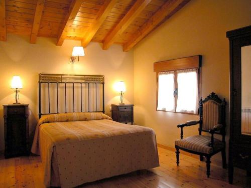 a bedroom with a bed and a chair and a window at La Vieja Cantina in Quintana Redonda