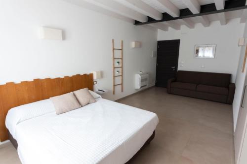 a bedroom with a white bed and a couch at Agriturismo Tiare dal Gorc in Gorgo
