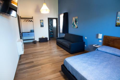 a blue room with a bed and a couch at Agriturismo Tiare dal Gorc in Gorgo