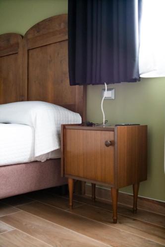a bedroom with a bed and a night stand with a lamp at Agriturismo Tiare dal Gorc in Gorgo