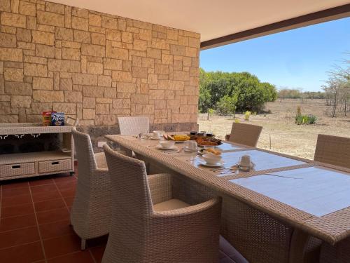 a dining room with a table and chairs with a view at Nyikani Villa Olpejeta in Nanyuki