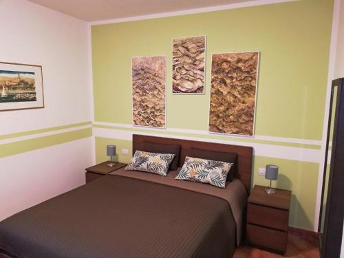 a bedroom with a bed and three paintings on the wall at Case Vacanze Borgo Faraldi in Villa Faraldi