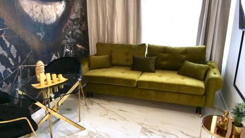a living room with a green couch and a table at Art Apartments Warszawska 21 Katowice in Katowice