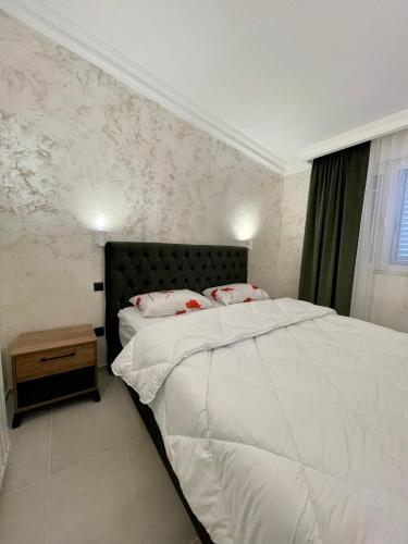 a bedroom with a large white bed and a window at Budva house Maja in Budva