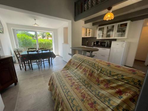 une chambre avec un lit et une cuisine avec une table dans l'établissement Maison rénovée climatisée, jardin, 4 couchages, à 1000m de la plage, parking privé, Saint-Cyprien - FR-1-225D-160, à Saint Cyprien Plage