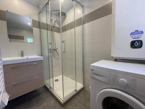 uma casa de banho com um chuveiro e uma máquina de lavar roupa em Maison Saint-Cyprien, 2 pièces, 4 personnes - FR-1-225D-160 em Saint-Cyprien-Plage