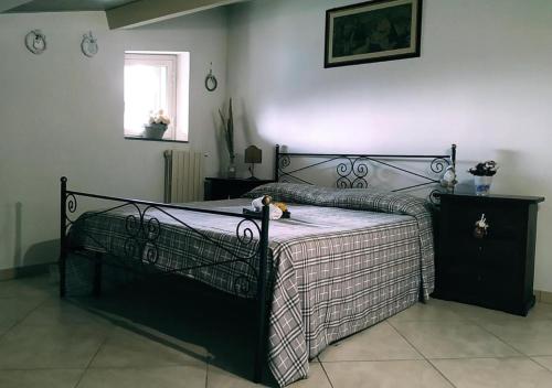 a black bed in a bedroom with a window at Peri Peri Guest House in Mascali