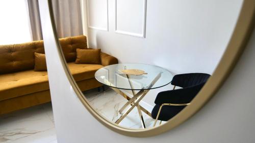 een glazen tafel en een stoel in een spiegel bij Art Apartments Warszawska 21 Katowice in Katowice