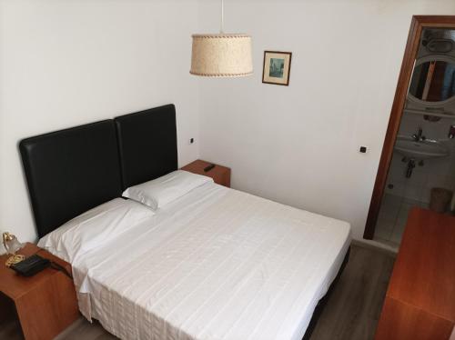 a bedroom with a large white bed and a shower at IHR Hotel Villa Emma in Canazei