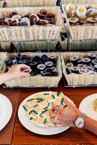 a woman holding a plate of food on a table at Hotel Brioni Mare in Lido di Jesolo