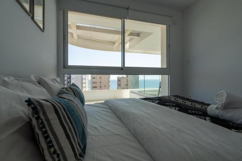 een slaapkamer met een wit bed en een groot raam bij Oyster 1-BR Apt in Larnaca in Larnaka