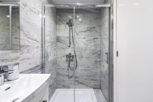 een badkamer met een douche en een glazen deur bij Oyster 1-BR Apt in Larnaca in Larnaka
