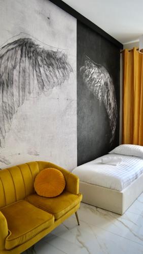 a living room with a couch and a wall with drawings at Art Apartments Warszawska 21 Katowice in Katowice