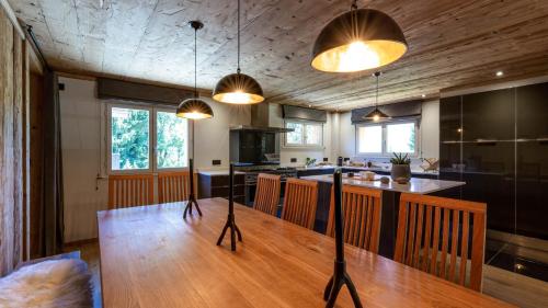 une cuisine avec une table en bois et quelques lumières dans l'établissement Chalet Birdie, aux Houches