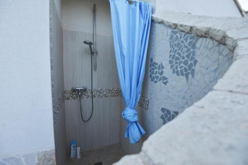 a shower with a blue curtain in a bathroom at Villa del Sole in Ostuni