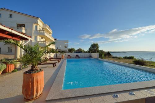 a large swimming pool with a balcony overlooking the ocean at Villa Jurac in Povljana