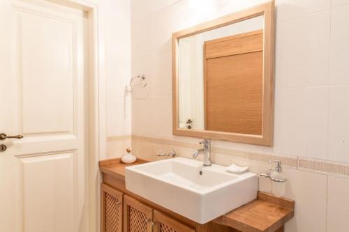a bathroom with a white sink and a mirror at Aristocratic Home Under Acropolis in Athens