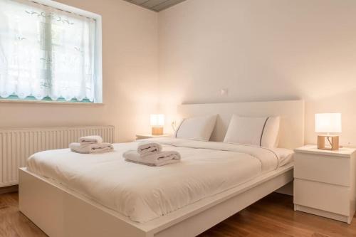 a white bedroom with a large white bed with towels on it at Aristocratic Home Under Acropolis in Athens