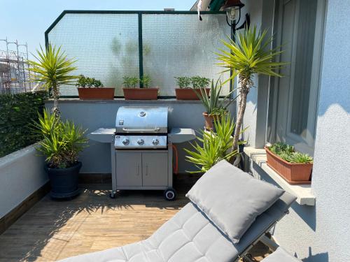 a patio with a grill on a balcony with potted plants at Appartamento La Terrazza in Trieste