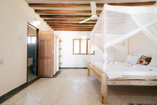 een slaapkamer met een bed en een plafond bij Sweet Beach Apartments in Jambiani