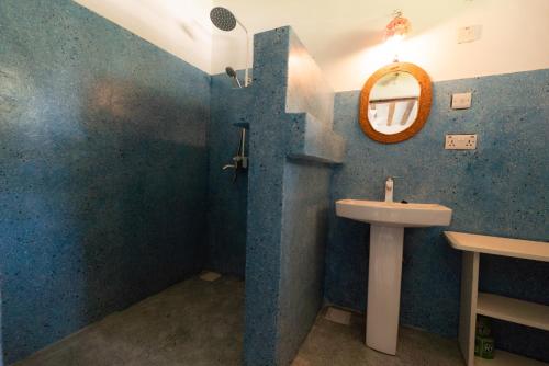 een badkamer met een wastafel en een spiegel bij Sweet Beach Apartments in Jambiani