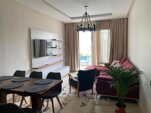 a living room with a table and a couch at Hivernage, Superbe appartement dans une résidence in Agadir