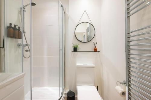a bathroom with a shower and a toilet and a mirror at Crescent Apartments in Newport