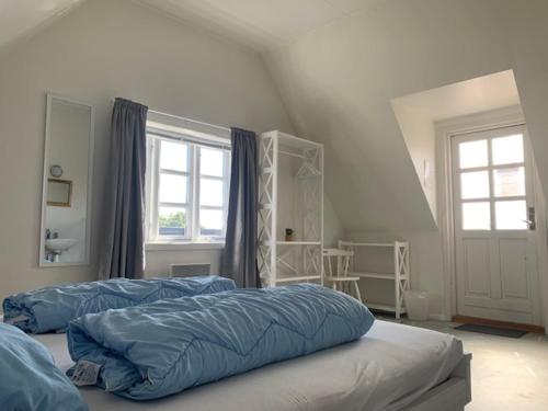 1 dormitorio con 2 camas y ventana en Gudhjem Vandrerhjem / Gudhjem Hostel, en Gudhjem