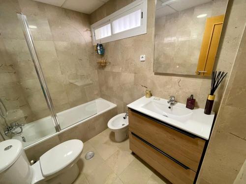 een badkamer met een toilet, een wastafel en een douche bij Apartamento primera línea de playa Isla Cristina Urbanización Zarati in Isla Cristina