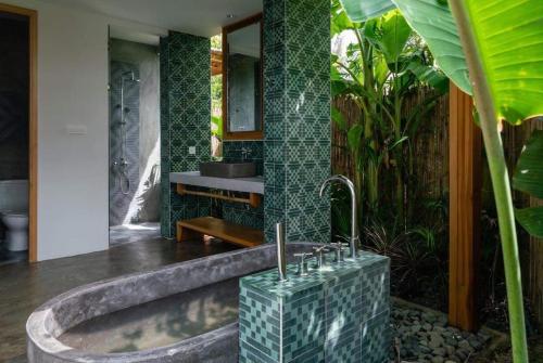 a bathroom with a tub and a sink in a room at Chi-Bu Riverside in Nhơn Trạch