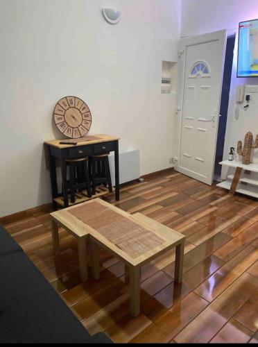 Cette chambre dispose d'une table et d'un bureau avec une horloge murale. dans l'établissement Studio meublé Tout équipé!!, à Boujan-sur-Libron