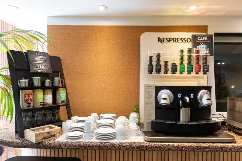 a counter with a coffee machine on a table at Eco Hotel Toledo in Toledo