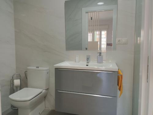 ein weißes Bad mit einem WC und einem Waschbecken in der Unterkunft Rentaly Holidays Apartamento Artes de Arcos Almería in Almería