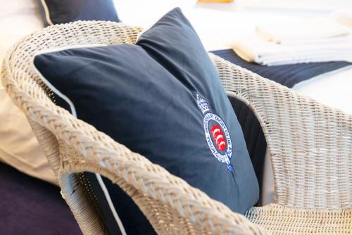 a black pillow sitting on a wicker chair at The Royal Burnham Yacht Club in Burnham on Crouch