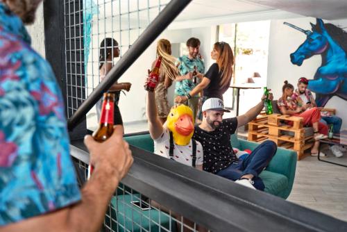 a group of people sitting on a couch holding beer bottles at Now Benidorm in Benidorm