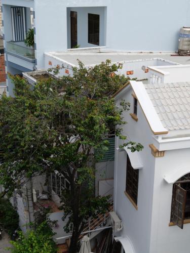 a tree in the middle of a white building at Moon house tropical garden - West side in Nha Trang