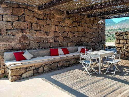 un muro di pietra con divano e tavolo di Kuddia Attalora a Pantelleria