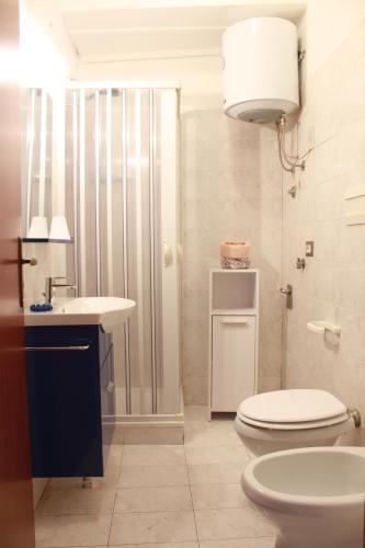 a white bathroom with a toilet and a sink at Fiore di Piesco-b&b di charme in Satriano di Lucania