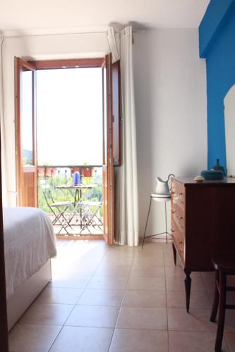 een slaapkamer met een bed en een glazen schuifdeur bij Fiore di Piesco-b&b di charme in Satriano di Lucania